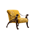 A vintage-style armchair with mustard yellow floral upholstery and dark brown carved dog-shaped arms connected by a harness, shown on a plain white background.