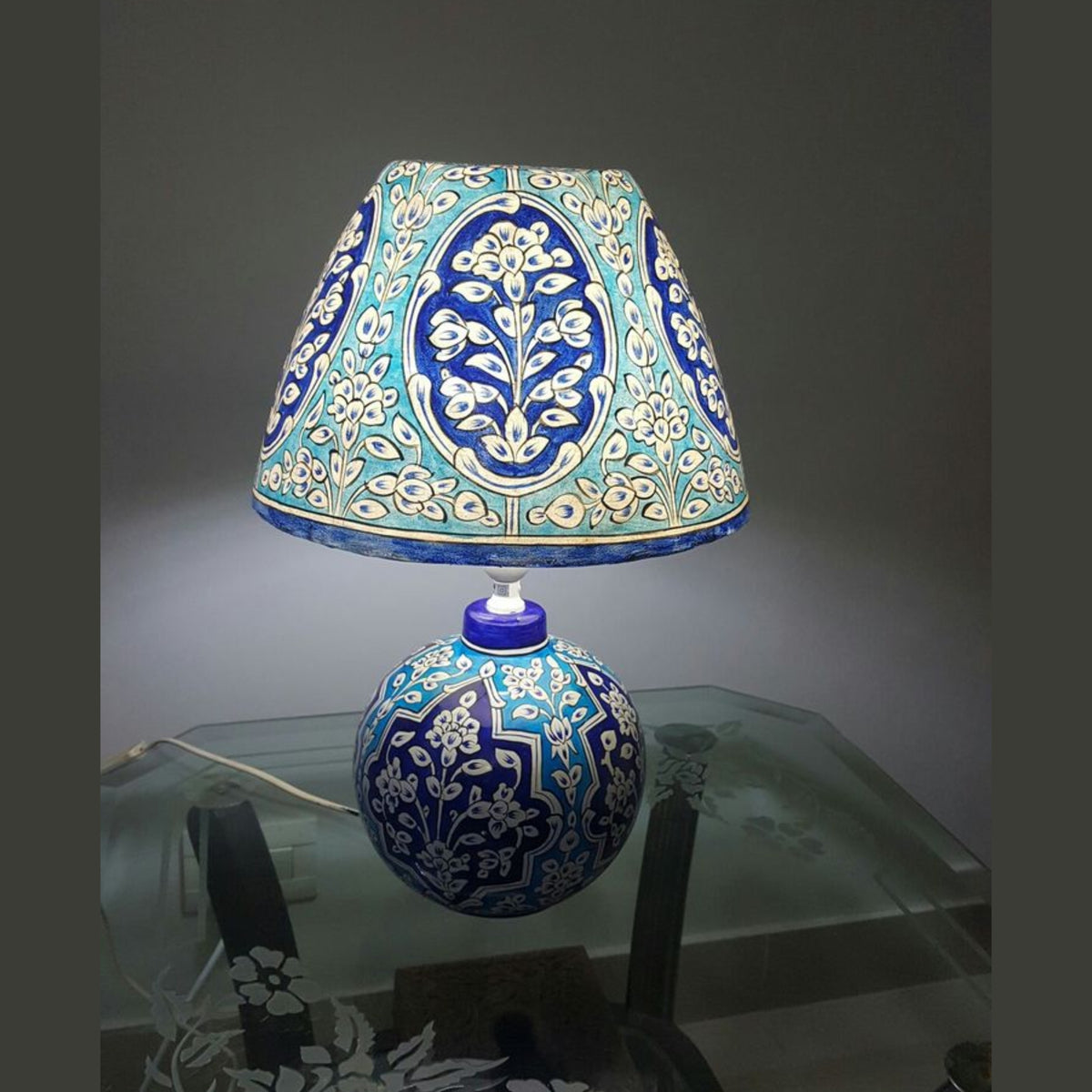 Decorative lamp with blue and white floral pattern on a dark background