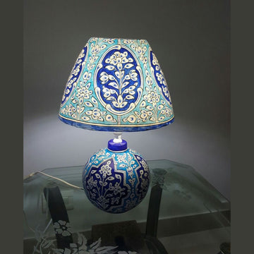 Decorative lamp with blue and white floral pattern on a dark background